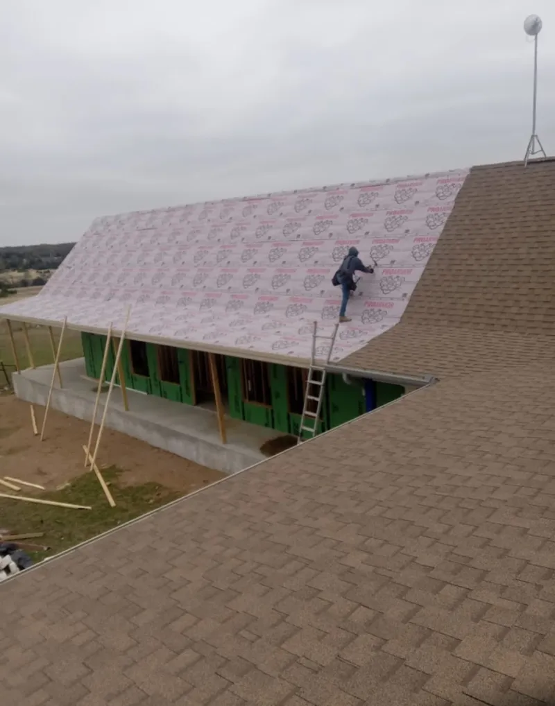 Worker preparing underlayment for a metal roof installation in Rio Rico